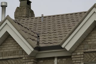 Before: a metal roof with broken tiles on the home, Surrey, British Columbia, ahead of a Black Interlock Slate aluminum roof