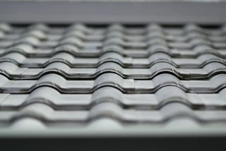 Before: a metal roof with broken tiles on the home, Surrey, British Columbia, ahead of a Black Interlock Slate aluminum roof