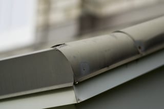Before: a metal roof with broken tiles on the home, Surrey, British Columbia, ahead of a Black Interlock Slate aluminum roof