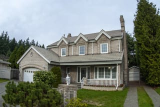 Before: a metal roof with broken tiles on the home, Surrey, British Columbia, ahead of a Black Interlock Slate aluminum roof