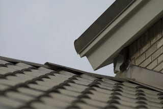 Before: a metal roof with broken tiles on the home, Surrey, British Columbia, ahead of a Black Interlock Slate aluminum roof