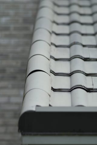Before: a metal roof with broken tiles on the home, Surrey, British Columbia, ahead of a Black Interlock Slate aluminum roof