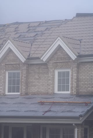 Black Interlock Slate aluminum roof on a tan house with a brown metal roof and white trim in a, Surrey, British Columbia