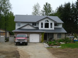 Charcoal Grey Interlock Slate aluminum roof on a colonial style home with a metal roof in a forested rural, Mission, British Columbia