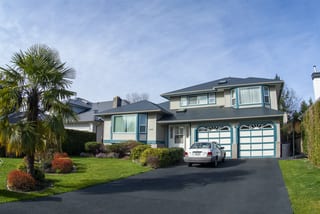 Deep Charcoal Interlock Slate aluminum roof on a two-storey home with garage and palm tree in a suburban, Surrey, British Columbia