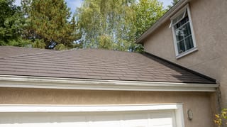 Tudor Brown Interlock Slate aluminum roof on a two-storey Tudor home with dormers in a suburban forest, Surrey, British Columbia