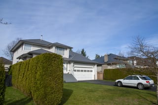 Musket Grey Interlock Slate aluminum roof on a white house with a garage and carport on a street with a, Surrey, British Columbia