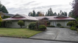 Tile Red Interlock Slate aluminum roof on a ranch home in a suburban setting with lush greenery, Delta, British Columbia