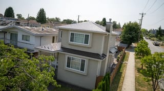 Colonial Brown Interlock Slate aluminum roof on a Colonial two-storey home with dormers among tall pines, Vancouver, British Columbia