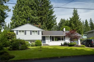 Tudor Brown Interlock Slate aluminum roof on a two-storey Tudor brown metal roofed home in a forested, North Vancouver, British Columbia