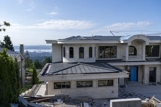 Deep Charcoal Interlock Slate aluminum roof being installed on the home, replacing new construction, West Vancouver, British Columbia