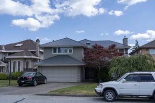 Deep Charcoal Interlock Slate aluminum roof on a beige two-storey home with dormers in a suburban, Richmond, British Columbia