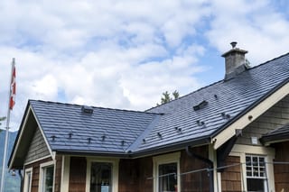 Black Interlock Slate aluminum roof on a brown single-family home with a metal roof in a mountain, Britannia Beach, British Columbia