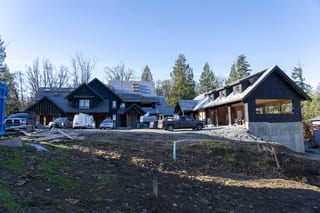 Musket Grey Interlock Slate aluminum roof being installed on a two-storey home with a black roof under construction in a, Abbotsford, British Columbia