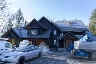Musket Grey Interlock Slate aluminum roof being installed on a two-storey home under construction in the woods, Abbotsford, British Columbia