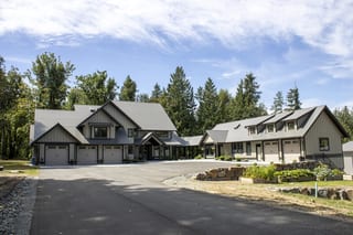 Large Craftsman-style home in Abbotsford BC with Interlock Musket Grey aluminum slate roofing across complex multi-gable rooflines and attached garage wing.
