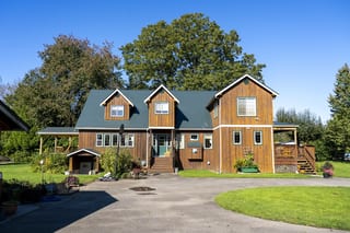 Hunter Green Interlock Slate aluminum roof on a two-storey home with a green roof in a forested area, Langley, British Columbia