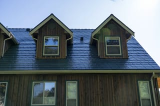 Hunter Green Interlock Slate aluminum roof on a green two-storey cottage with a metal roof in a forested, Langley, British Columbia