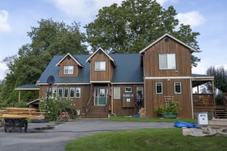 Hunter Green Interlock Slate aluminum roof on a brown two-storey home with a hunter green metal roof in, Langley, British Columbia