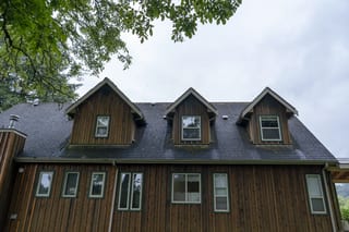 Hunter Green Interlock Slate aluminum roof on a modern home with a hunter green metal roof in a forested, Langley, British Columbia