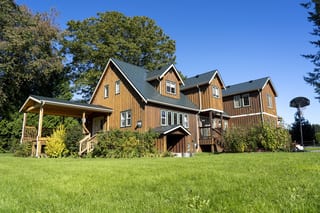 Hunter Green Interlock Slate aluminum roof on a brown two-storey home with a Hunter Green metal roof in a, Langley, British Columbia