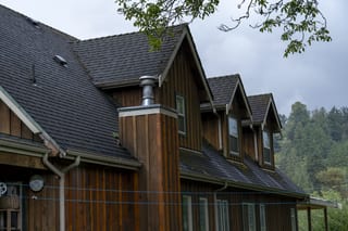Hunter Green Interlock Slate aluminum roof on a brown single-family chalet with a hunter green metal roof, Langley, British Columbia