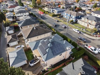 Deep Charcoal Interlock Slate aluminum roof on a beige two-storey home with dormers in a suburban setting, Burnaby, British Columbia