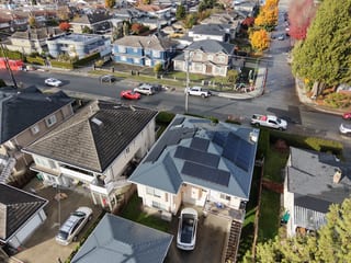 Deep Charcoal Interlock Slate aluminum roof on a white house with an Interlock Slate roof among green, Burnaby, British Columbia