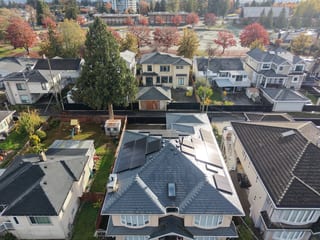 Deep Charcoal Interlock Slate aluminum roof on a two-storey home with dormers among tall trees in a, Burnaby, British Columbia