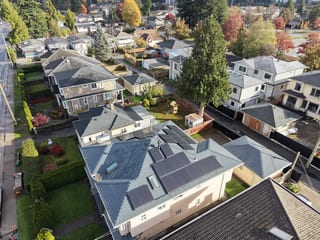 Deep Charcoal Interlock Slate aluminum roof on a two-storey home with a grey roof among tall trees, Burnaby, British Columbia