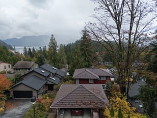 Colonial Brown Interlock Shake aluminum roof on a colonial-style home with brown roof among tall trees, North Vancouver, British Columbia