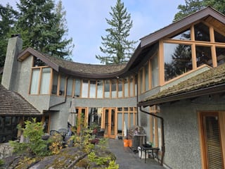 Center elevation of a West Vancouver, BC home during tear-off of the original 30-year-old cedar shake roof, prior to its Interlock aluminum Tudor Brown slate replacement.