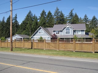 Weathered Interlock Slate aluminum roof on a two-storey home with grey metal roof and a fence among, Duncan, British Columbia