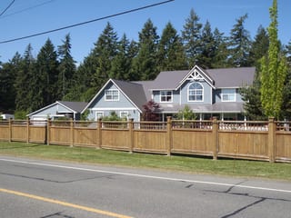 Weathered Interlock Slate aluminum roof on a white two-storey home with dormers in a rural setting, Duncan, British Columbia