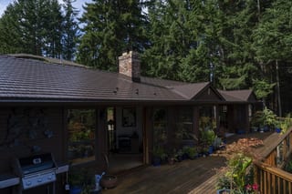 Colonial Brown Interlock Cedar Shingle aluminum roof on a colonial brown single-storey home with a chimney among, Salt Spring Island, British Columbia