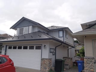 Black Interlock Slate aluminum roof on a two-storey house with a metal roof in a rural coastal, Sooke, British Columbia