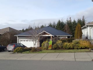 Black Interlock Slate aluminum roof on a black single-family ranch home in a suburban forest, Sooke, British Columbia