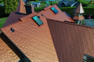 Copper Penny Interlock Slate aluminum roof on a red house with a copper penny metal roof in a suburban, Ladysmith, British Columbia