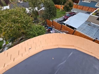 Copper Penny Interlock Slate aluminum roof on a grey home with a metal roof in a suburban neighbourhood, Victoria, British Columbia