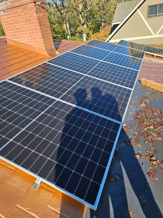 Copper Penny Interlock Slate aluminum roof being installed on a brown roofed home with dormers among tall trees, Victoria, British Columbia