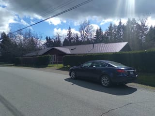 Tudor Brown Interlock Slate aluminum roof on a brown Tudor home in a forested area, Duncan, British Columbia