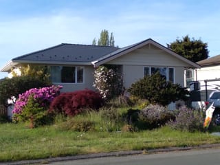 Deep Charcoal Interlock Slate aluminum roof on a beige ranch-style home with a brown roof in an, Victoria, British Columbia
