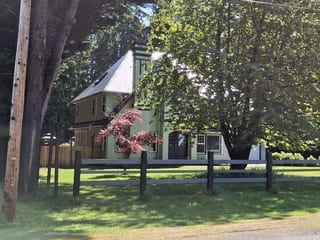 Deep Charcoal Interlock Slate aluminum roof on a two-storey home with dormers in a lush green yard, Bowser, British Columbia