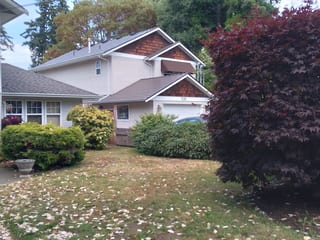 Tudor Brown Interlock Cedar Shingle aluminum roof on a Tudor style home with a metal roof surrounded by trees, Victoria, British Columbia