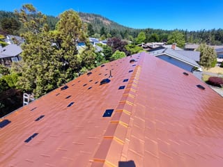 Copper Penny Interlock Slate aluminum roof on a Copper Penny metal roof on a forested suburban home, Victoria, British Columbia