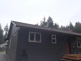 Before: a leaking asphalt shingle roof on the home, Comox, British Columbia, ahead of a Black Interlock Slate aluminum roof