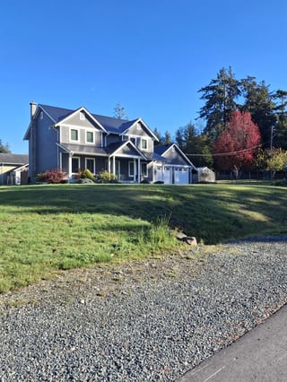 Black Interlock Slate aluminum roof on a large grey house with a black metal roof in a coastal, Sooke, British Columbia