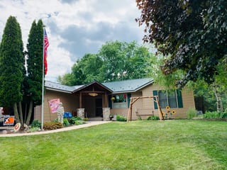Hunter Green Interlock Shingle aluminum roof on a tan ranch-style home with a hunter green metal roof in a, Winnebago, Illinois