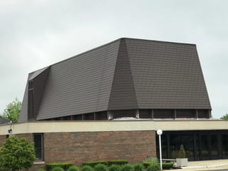 White Interlock IB Membrane aluminum roof on a suburban home with a brown metal roof among tall trees, Chicago Heights, Illinois