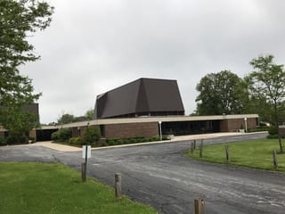 White Interlock IB Membrane aluminum roof on a brown single-storey home with a gable roof in an urban, Chicago Heights, Illinois